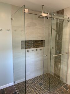 Remodeled bathroom featuring a curbless glass shower stall.